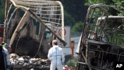 Tim ahil kepolisian Jerman sedang memeriksa kerangka bis wisata yang terbakar di Jalan Raya A9. dekat Muenchberg, Jerman, 3 Juli 2017. (Nicolas Armer/dpa via AP)