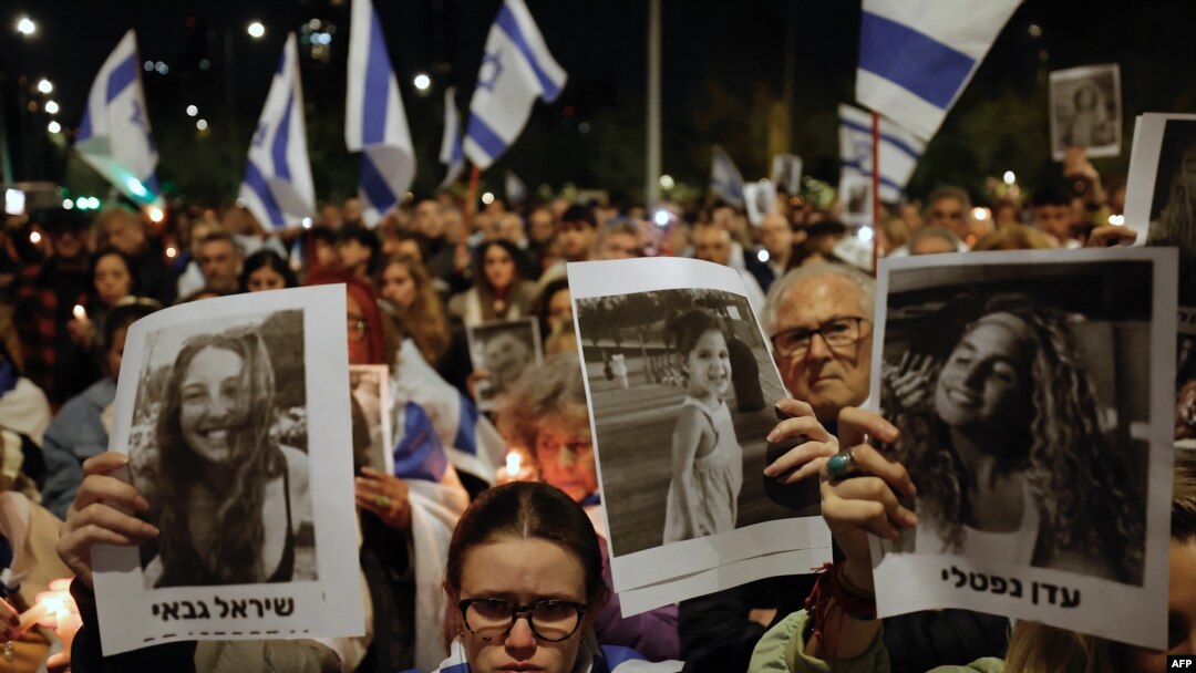Ljudi prikazuju slike žrtava Hamasovog smrtonosnog napada na Izrael tokom demonstracija podrške Izraelu, u Santiagu 11. oktobra 2023.