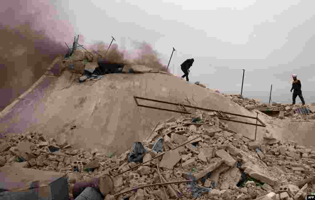 Rescue workers known as the White Helmets search for victims amid the rubble of a house that was destroyed during an an airstrike by pro-regime forces in the western countryside of Aleppo, Syria.