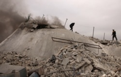 Rescue workers known as the White Helmets search for victims amid the rubble of a house that was destroyed during an an airstrike by pro-regime forces in the western countryside of Aleppo, Syria, Feb. 12, 2020.