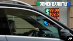 2023年8月14日，一名女子开车经过俄罗斯莫斯科的一家货币兑换所。（美联社照片）