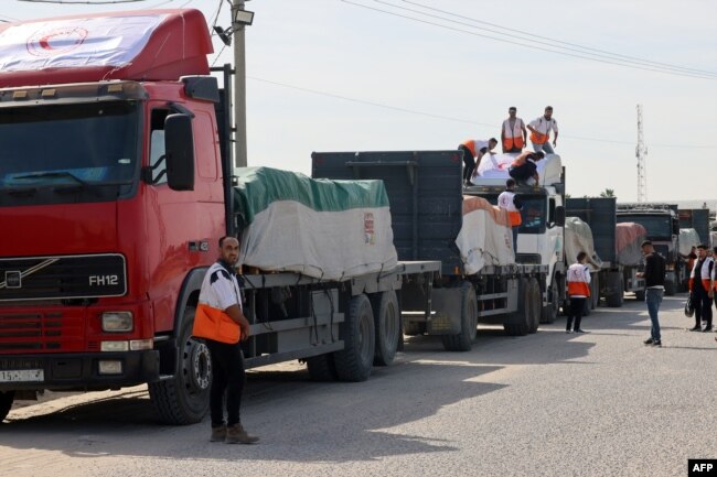 Yardım kamyonları Gazze'ye girdikten sonra malzemeleri boşaltıyor