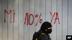Una mujer con mascarilla pasa delante de un grafiti contra las Administradoras del Fondo de Pensiones en Santiago, Chile, el 22 de julio de 2020.