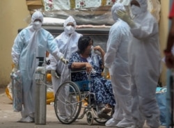 Health workers attend to a patient at the Jumbo COVID-19 hospital in Mumbai, India, Thursday, April 22, 2021. New infections are rising faster in India than any other place in the world.