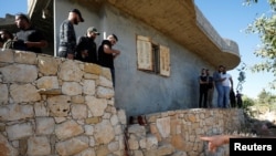 People check the scene where three Palestinians were killed by Israeli forces during a raid, in Beit Anan in the Israeli-occupied West Bank, Sept. 26, 2021.