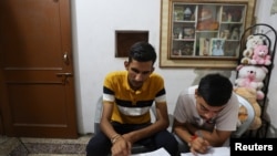 Vijay Chauhan, 18, and Vishal, 18, who both take English language classes at Western Overseas institute, go through their notes at Vijay's house in the village of Adhoya in Ambala district, India, August 15, 2022. REUTERS/Anushree Fadnavis