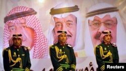 Saudi royal guards stand on duty in front of portraits of King Abdullah bin Abdulaziz (R), Crown Prince Salman bin Abdulaziz (C) and second deputy Prime Minister Muqrin bin Abdulaziz.