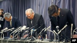 Pemimpin dan CEO Suzuki Motor Corp. Osamu Suzuki, (tengah), bersama presiden perusahaan itu, Toshihiko Suzuki (kanan) dan wakilnya Osamu Honda melmbungkukkan badan mereka saat memulai konferensi pers di Tokyo (18/6).