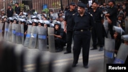 Police stand guard during a protest against the military council outside Egypt's parliament in Cairo, June 19, 2012. 