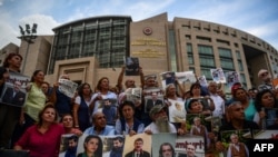 Protesters hold pictures of jailed Cumhuriyet journalists during a demonstration against their arrest outside the courthouse of Istanbul, Turkey, July 28, 2017.