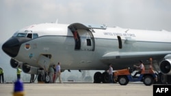 Awak pesawat Boeing 707 milik Angkatan Udara AS melakukan pemeriksaan pesawat di landasan bandara Sultan Iskandar Muda, Aceh Besar, Aceh, 25 Maret 2017, pasca melakukan pendaratan darurat sehari sebelumnya. (Foto: AFP).