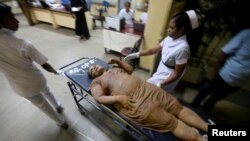 Hospital staff pull a stretcher bearing an injured woman after a garbage dump collapse that buried houses in Colombo, Sri Lanka, April 14, 2017.