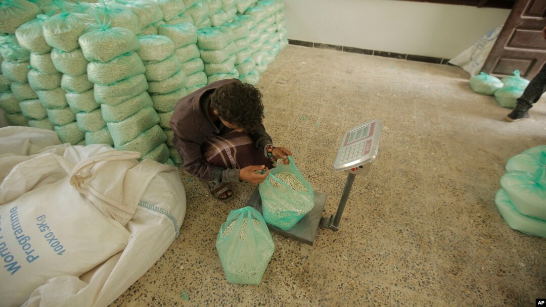 Seorang pekerja menimbang bahan makanan dari Program Pangan Dunia untuk dibagikan di Sanaa, Yaman, 25 Agustus 2019. 