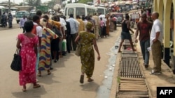 Des Gabonais attendent pour un taxi ou le bus dans une rue de Libreville, au Gabon, le 5 avril 2011.