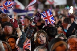 FILE - Brexit supporters wave Union flags during Brexit celebrations in central London, Jan. 31, 2020.