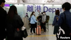 FILE - Don Yip waves to his friends and relatives before his departure at Hong Kong International Airport to Britain, in Hong Kong, Feb. 17, 2021. 