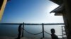 FILE - A man and his son are seen at a jetty during a search and rescue in Kuala Langat outside Kuala Lumpur, off Malaysia's western coast, June 18, 2014.