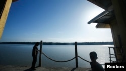 FILE - A man and his son are seen at a jetty during a search and rescue in Kuala Langat outside Kuala Lumpur, off Malaysia's western coast, June 18, 2014.