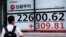 A man wearing a face mask to help curb the spread of the coronavirus looks at an electronic stock board showing Japan's Nikkei 225 index at a securities firm in Tokyo on July 13, 2020. 