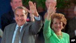 FILE - Then-Republican presidential nominee Bob Dole and his wife Elizabeth wave to well-wishers at a rally in downtown Phoenix, Arizona, Oct. 25, 1996. 