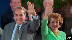FILE - Then-Republican presidential nominee Bob Dole and his wife Elizabeth wave to well-wishers at a rally in downtown Phoenix, Arizona, Oct. 25, 1996. 