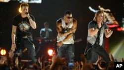 Nelly, center, and Brian Kelley, left, and Tyler Hubbard, of musical group Florida Georgia Line, perform at ACM Presents: Tim McGraw's Superstar Summer Night at the MGM Grand Garden Arena, April 8, 2013, in Las Vegas.