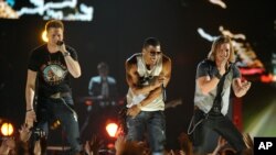 Nelly, center, and Brian Kelley, left, and Tyler Hubbard, of musical group Florida Georgia Line, perform at ACM Presents: Tim McGraw's Superstar Summer Night at the MGM Grand Garden Arena, April 8, 2013, in Las Vegas.