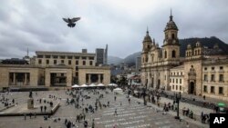 FILE - Ativists who have received death threats display the names of killed leftist activists as part of an art installation by Colombia artist Doris Salcedo at Plaza Bolivar in downtown Bogota, Colombia, June 10, 2019. 