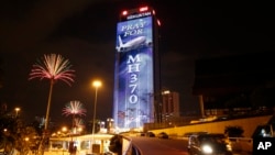 An office building is illuminated with lights displaying "Pray for MH370" in Kuala Lumpur, Malaysia, March 24, 2014. 