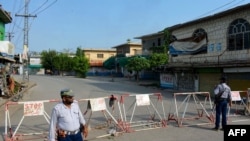 Polisi berjaga di sepanjang jalan yang dibarikade, sehari setelah mereka diserang oleh pasukan bunuh diri militan di Bannu, 16 Juli 2024. (Karim ULLAH / AFP)