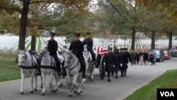 Một toán ngựa kéo quan tài phủ cờ được đặt trên một chiếc xe đến địa điểm huyệt mộ