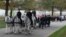 Caisson horses pull the flag-draped casket of Retired U.S. Army Col. Robert W. Gambino to its final resting place at Arlington National Cemetery. (VOA/J. Taboh 