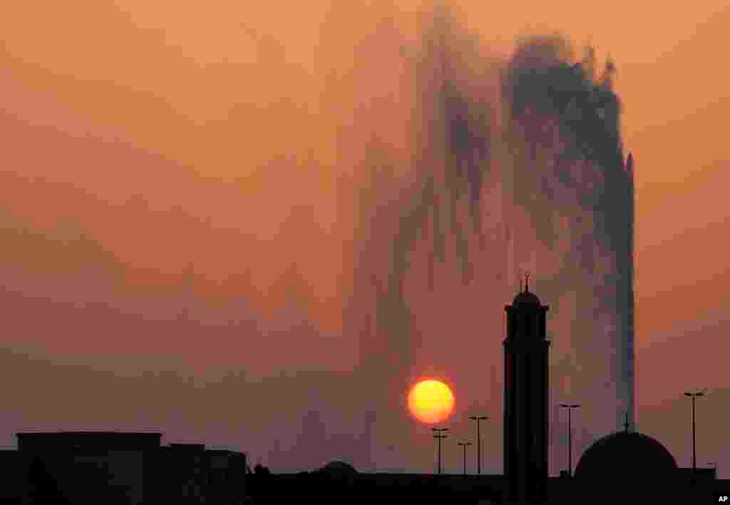 The sun sets behind a mosque and the Jiddah fountain, in Jiddah, Saudi Arabia, Aug. 29, 2019.