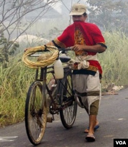 Seorang petani menutup hidungnya dari asap kebakaran hutan di Rokan Hilir, Riau tahun 2005 silam. Berbagai organisasi pemuda menilai kebijakan pemerintah tidak berpihak pada petani (foto: dok).