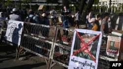 FILE - A poster featuring Myanmar military commander-in-chief Min Aung Hlaing is displayed during a protest against the military coup, in Yangon, Feb. 11, 2021. The U.S. announced sanctions against Min Aung Hlaing's two adult children on March 10, 2021.