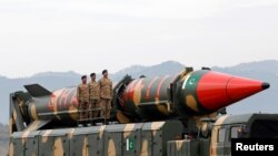 Pakistani military personnel stand beside a Shaheen III surface-to-surface ballistic missile during Pakistan Day military parade in Islamabad, Pakistan, March 23, 2019.