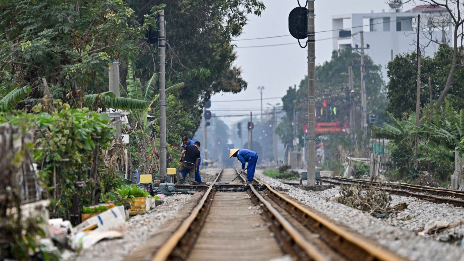This photo taken on Feb. 13, 2025, shows workers at a railway crossing in Hanoi. 