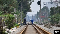 This photo taken on Feb. 13, 2025, shows workers at a railway crossing in Hanoi. 