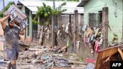 Un hombre intenta recuperar sus pertenencias en medio del lodo y los escombros que dejó el desborde del río Chamelecón luego de las fuertes lluvias provocadas por el huracán Iota, en el municipio de La Lima, Honduras, el 21 de noviembre 2020.