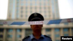 A police officer stands guard at the entrance to the Jinan Intermediate People's Court. August 24, 2013. 