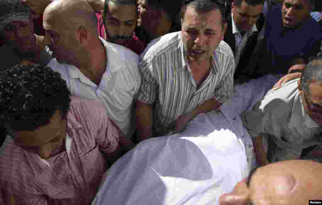 The body of Tunisian opposition politician, Mohamed Brahmi, is carried into an ambulance after he was shot dead outside of his home&nbsp;in Tunis, July 25, 2013.&nbsp;