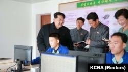 North Korean leader Kim Jong-un, left, gives field guidance at the Wonsan Shoes Factory in this undated photo released by North Korea's Korean Central News Agency (KCNA) in Pyongyang, Nov. 27, 2015. 
