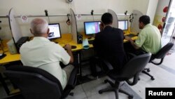 FILE - People surf the Internet at an Internet cafe in Baghdad, Nov. 11, 2012. 