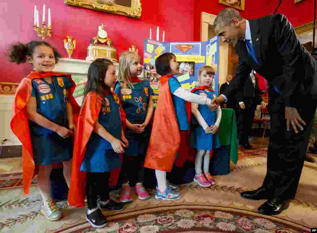 Dressed in super hero capes, six-year-old Girl Scouts, from left, Alicia Cutter, Addy O’Neal, Emery Dodson, Karissa Cheng, and Emily Bergenroth, of Tulsa, Oklahoma, meet with President Barack Obama before showing him their project during his tour of the White House Science Fair in Washington. The girls used Lego pieces and designed a battery-powered page turner to help people who are paralyzed or have arthritis.