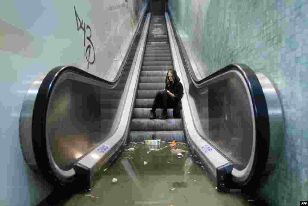 A girl calls for assistance after she is trapped by the water on a flooded Ryparken train station during a heavy rainstorm in Copenhagen, Denmark.