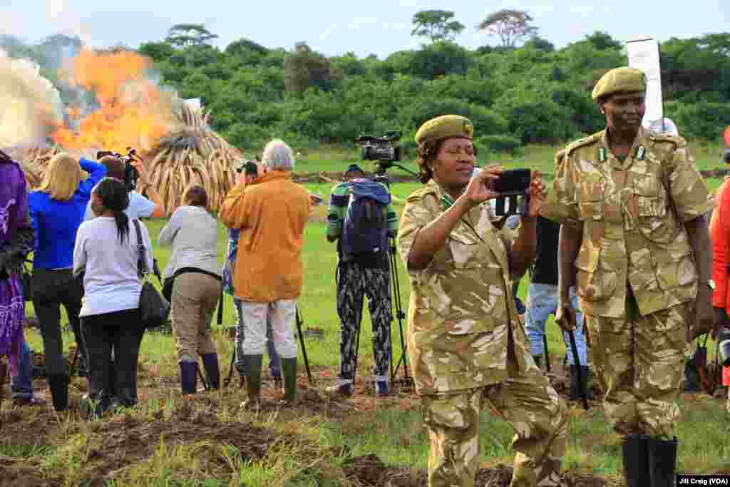 Kenya Wildlife Service rangers photograph themselves at a massive burn of elephant ivory and rhinoceros horn at the end of a three-day anti-poaching summit, Nairobi National Park, Kenya, April 30, 2016.