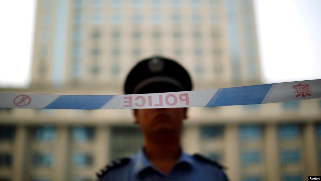 Seorang petugas kepolisian berjaga di depan pengadilan Jinan di provinsi Shandong, 24 Agustus 2013 (Foto: dok). 