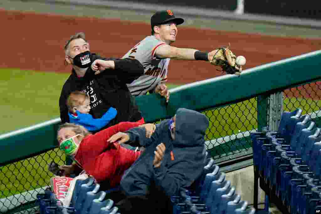 San Francisco Giants right fielder Mike Yastrzemski cannot reach a pop foul ball by Philadelphia Phillies' Rhys Hoskins during the ninth inning of a baseball game, in Philadelphia, Pennsylvania, April 20, 2021.