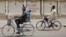 Two boys ride their bicycles past a sign reading "Stop killing Muslims Army" on a wall in Kano, Nigeria, April 8, 2016. Nigeria's Kaduna state government has secretly buried hundreds of minority Shi'ite Muslims in a mass grave.