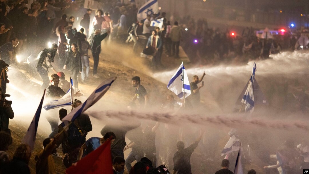 Polisi Israel menggunakan meriam air untuk membubarkan demonstran yang memblokir jalan raya selama aksi protes terhadap rencana pemerintahan PM Netanyahu untuk merombak sistem peradilan, di Tel Aviv, Senin, 27 Maret 2023.
